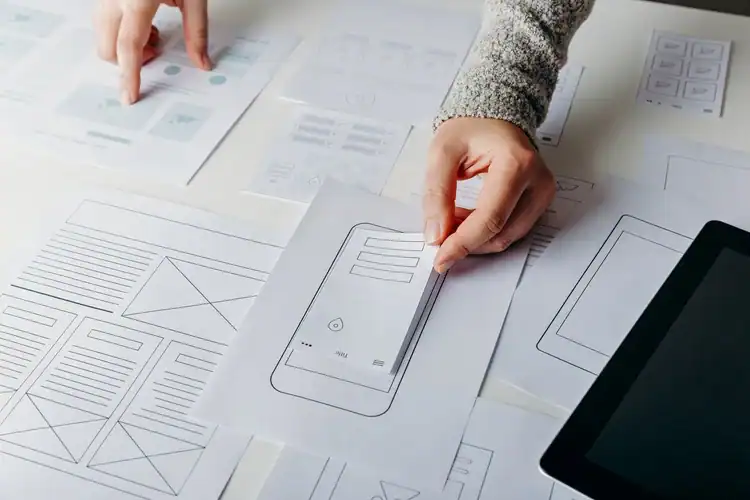 Wireframing and designing mobile app layouts for innovative digital solutions at a designer charrette.
